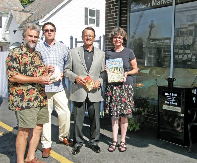 In photo, (l-r) Dave Besnia, Bourbeau’s owner Paul Grimley (in back), Rep. Dennis Rosa (D-Leominster) and Deanne Bellefeuille- Besnia stand outside the market on Water Street, holding selections from the city’s first Little Free Library.
