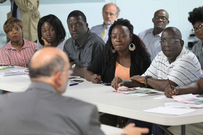 Members of Rhode Island’s Liberian community listen to Dr. Michael Fine, director of the state Department of Health, speak Thursday at St. Paul’s Evangelical Lutheran Church in Providence on preventing the spread of the Ebola virus.