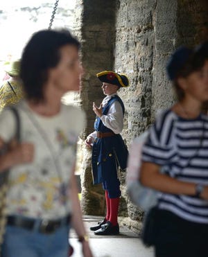 ALEX.SANCHEZ@STAUGUSTINE.COM Jason Davis Jr., 13, explains to a visitor, Kevin Edwards, the history of the coquina walls that make up the Castillo de San Marcos Museum as visiting hours come to a close on Saturday, August 16, 2014. He has been volunteering there for over a year now along with his father and sister.