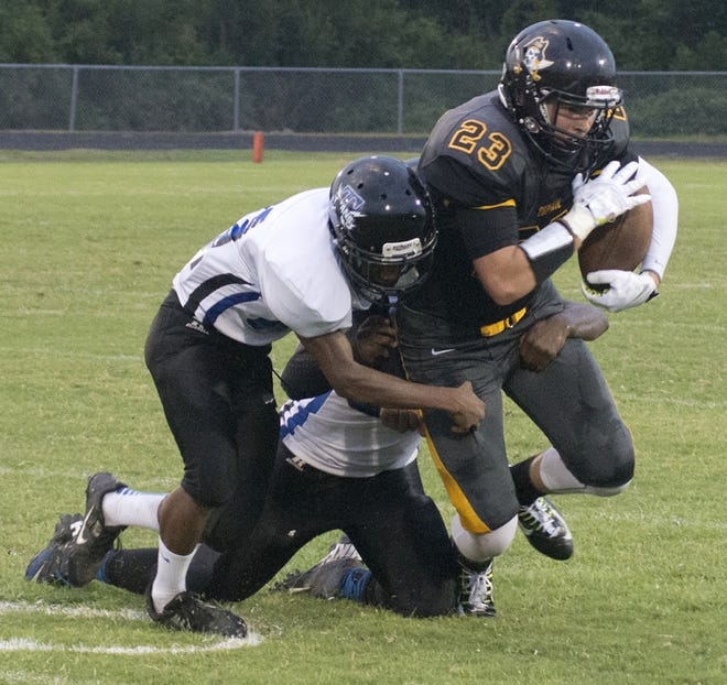 Trask defenders tackle Topsail's Zander Hunt during first-half action Friday, Aug. 22, 2014.