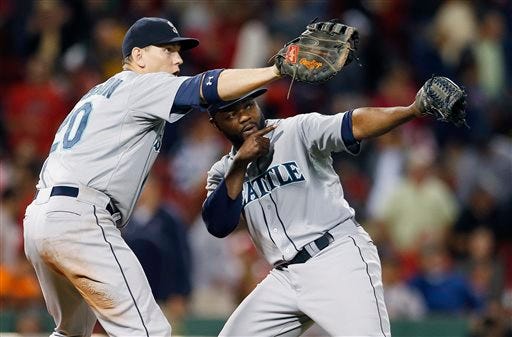 Seattle Mariners' Logan Morrison, left, and Fernando Rodney celebrate after they defeated the Boston Red Sox 5-3 in a baseball game in Boston, Friday, Aug. 22, 2014.