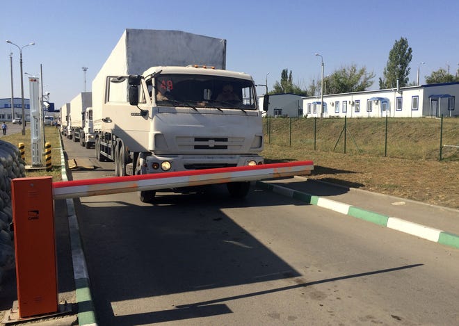 The first trucks from the Russian aid convoy wait to cross the border control point with Ukraine in the Russian town of Donetsk, Rostov-on-Don region, Russia, Saturday, Aug. 23, 2014. After traveling to besieged rebel-held areas, some of the trucks have now begun crossing back into Russia.