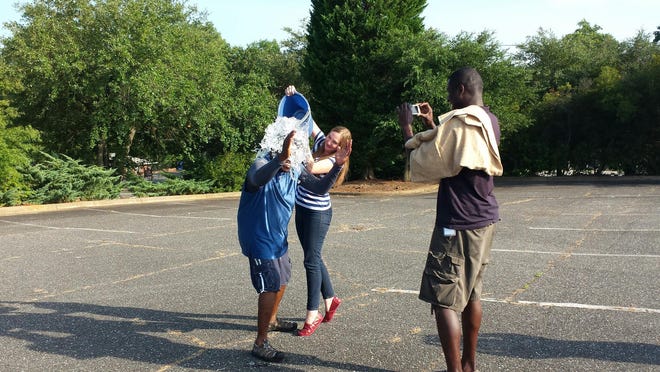 Shelby Star photographer Brittany Randolph dumps ice on Ken Lemon, reporter with Gazette and Star news partner WSOC-TV, as he takes part in the ALS Ice Bucket Challenge. WSOC-TV photographer Kelvin Wylie records the challenge for Facebook.