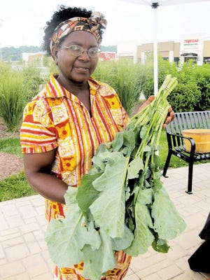 Janet Zintambila of Normal holds some rappini she sells at her vegetable stand at the East Peoria Farmer’s Market. Zintambila has a 2-acre farm in Carlock. She offers a variety of vegetables at her stand and also has a website umojagardens.blogspot.com.