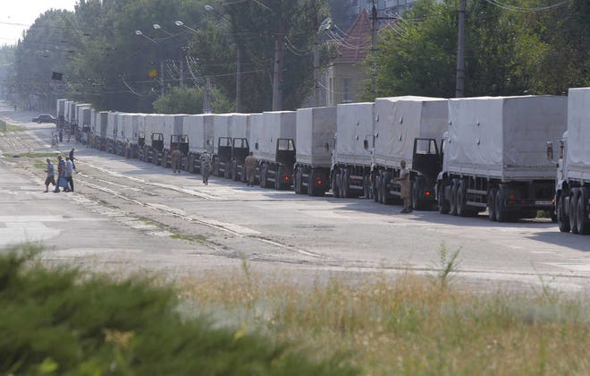 Drivers of the first trucks of the Russian aid convoy are parked in the city of Luhansk, eastern Ukraine, Friday, Aug. 22, 2014. The first trucks in a Russian aid convoy crossed into eastern Ukraine on Friday, after more than a week's delay. (AP Photo/Sergei Grits)