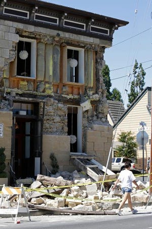 A pedestrian passes a building with a collapsed wall after an earthquake Sunday in Napa, Calif. Officials say an earthquake with a preliminary magnitude of 6.0 has been reported in California's northern San Francisco Bay area.