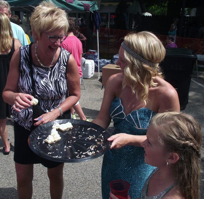Allyson Lane, center, and Ava Leslie, right, offer items from the Mermaid Bar and Grill to visitors at the Taste of Saugatuck on Sunday. Jim Hayden/Sentinel staff