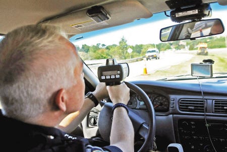 Portsmouth Police Chief Stephen DuBois demonstrates a laser radar gun on Market Street Extension as cars head into the Port City.