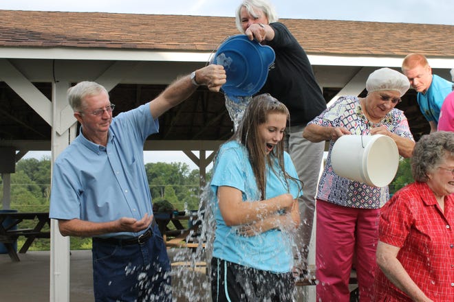 Doug Toney dumps a bucket of ice water on his granddaughter Natalie Deaton in a church wide ALS Ice Bucket Challenge. Toney was diagnosed with ALS in June.