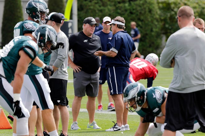 Philadelphia Eagles head coach Chip Kelly, center left, listens as he talks with New England Patriots head coach Bill Belichick during an NFL Football training camp scrimmage of the New England Patriots and Philadelphia Eagles in Foxborough, Mass., Tuesday, Aug. 12, 2014. Patriots coach Bill Belichick got some roster trimming out of the way yesterday, unloading some big names. Tommy Kelly, Will Smith and James Anderson all got the boot, according to several sources.