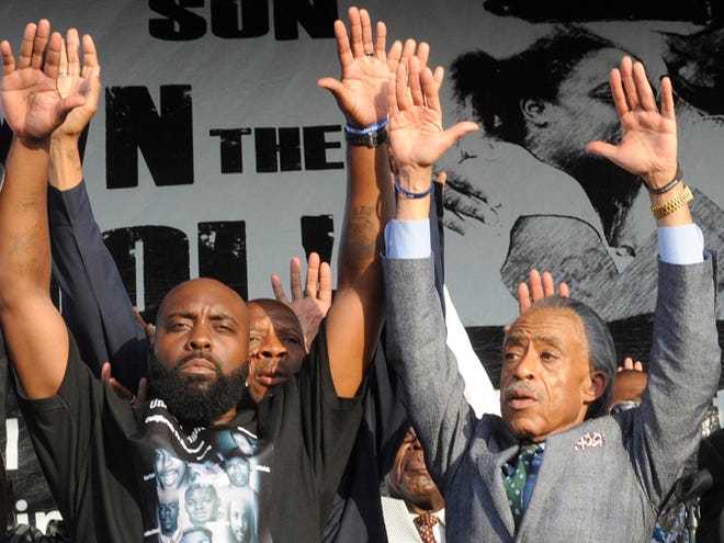 Father of slain teen Michael Brown, Michael Brown Sr., left, and the Rev. Al Sharpton, right, gesture to the crowd Sunday at Peace Fest in St. Louis. Tomorrow all I want is peace," Brown Sr. told hundreds of people in St. Louis’ largest city park Sunday during brief remarks at a festival that promoted peace over violence.