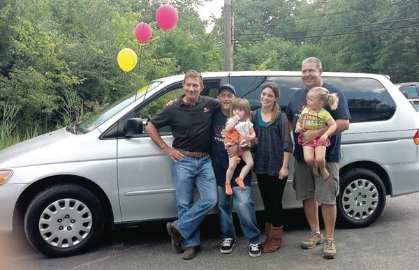 NAPA sales representative Jim Messina, at far left, and Elite Automotive owner Dave Hergert, at far right, congratulate Yolanda Dones and her family on the acquisition of a refurbished van as part of the auto donation program at Project Self- Sufficiency.