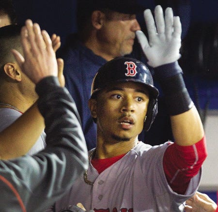 Mookie Betts is congratulated in the dugout after he hit a home run off Toronto Blue Jays pitcher J.A. Happ during the fifth inning.