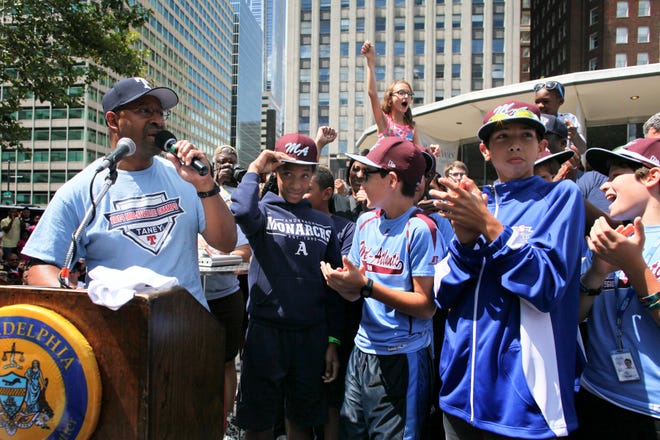 In this Sunday, Aug. 24, 2014, file photo, Philadelphia Mayor Michael Nutter, left, introduces members of the Taney Dragons as they are greeted by fans and city officials during a rally to celebrate the team's return to Philadelphia after competing in the Little League World Series.