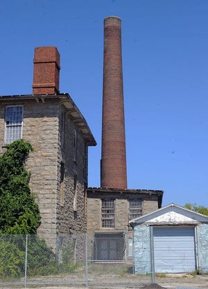 The 200-foot smokestack at King Philip Mill is in danger of collapsing because of a large hole in its base, city officials announced Tuesday.