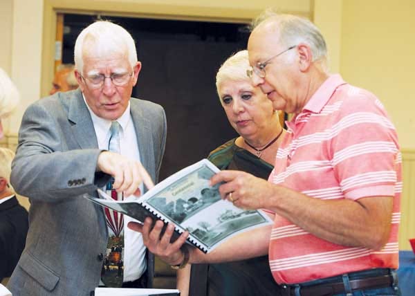 Photo by Marie Dirle/New Jersey Herald From left, John Kibildis, vice president of the Ogdensburg Historical Society; Anna Zampella, member of the society, and Tom Kuplin, Ogdensburg resident, leaf through a booklet titled “Centennial."
