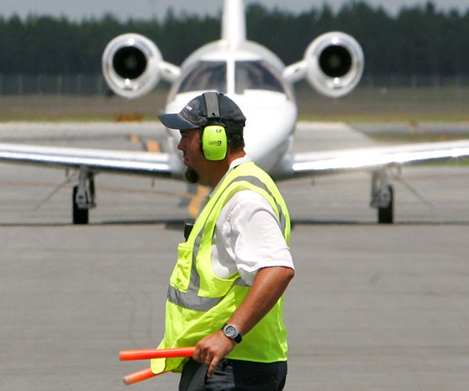 David Dial directs a plane near Sheltair, the Northwest Florida Beaches International Airport’s fixed based operator, in 2011. The airport near West Bay is planning to build a new ramp just north of Sheltair.