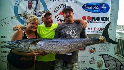 Miki McClung, left, along with her husband Capt. Larry McClung and angler Jeff Davis show off the winning king mackerel, a 57.9-pounder, caught on the Come Fly With Me. Miki won the Ladies Division with a 36.9-pound mackerel.