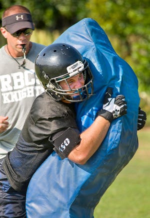 Rocky Bayou's Duncan Foster makes contact with a tackling dummy during a recent practice.