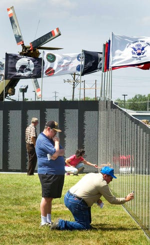 Jay Kirschemann, of Topeka, watches as Al Holloway, of Baldwin City, takes a picture Thursday of the Vietnam Traveling Wall currently at the Museum of the Kansas National Guard at Topeka Regional Airport.