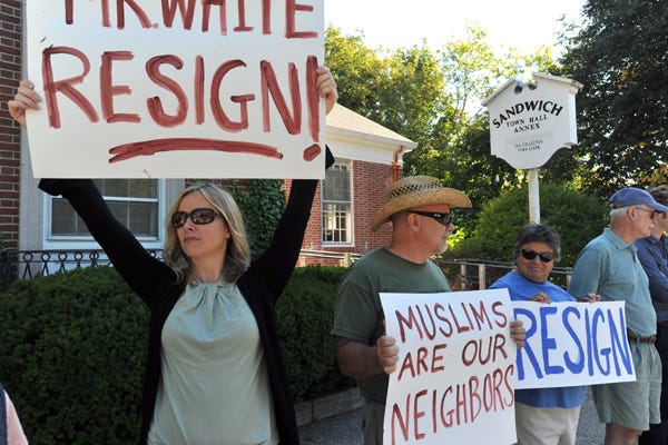 SANDWICH -- 08/29/14 -- Jessica Linehan,left, joins husband, Gary, Vianna Heath, Paul Houlihan and Patrick Prendergast, right in protesting comments made by Sandwich Town Clerk Taylor White in front of Town Hall on Friday.