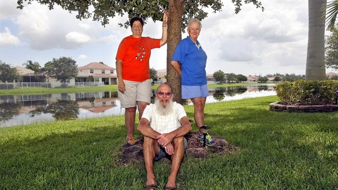 Homeowners Carolyn Rolandelli (left), and Russ and Anita Warnet, outside their home in the Waterford Court neighborhood in Palm Beach Plantation. (Bill Ingram / Palm Beach Post)