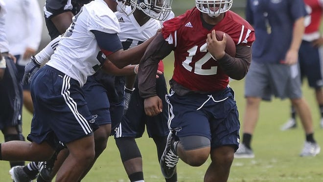Florida Atlantic University quarterback Jaquez Johnson runs the ball while scrimmaging during the first day of practice, Thursday, July 31, 2014. (Damon Higgins / The Palm Beach Post)