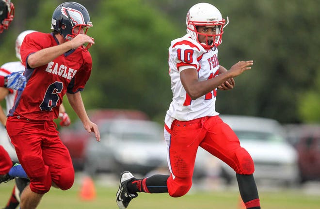 FSDB's QB Cedric Scott runs the ball pursued by Beacon of Hope's Bobby Apte during the first quarter of high school football action at Pomar Field in St Augustine, Fla., Thursday, Sept. 5, 2013. (The Florida Times-Union, Gary McCullough)