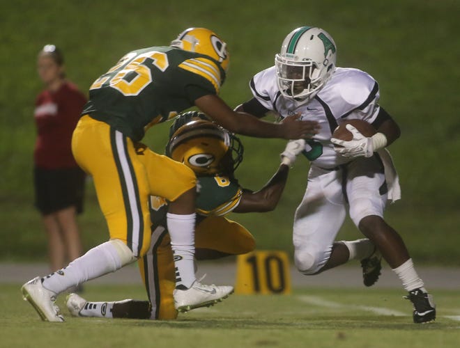 Crest defenders Traquan Hopper (6) and Aaron Ramseur (26) converge on Ashbrook's Jeff Glenn (20) Friday night game at Sid Bryson Stadium. The Chargers won, 31-7. (Ben Earp / The Star)