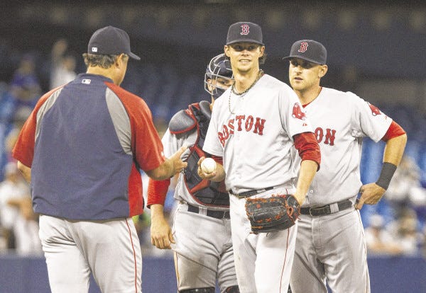 Boston Red Sox manager John Farrell takes the ball from starting pitcher Clay Buchholz during the ninth inning of a baseball game against the Toronto Blue Jays on Monday, Aug. 25, 2014, in Toronto.