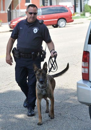 Dover Patrolman William Nedrow and his partner Rex prepare to check a car for illegal substances recently.