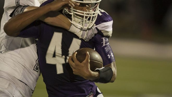 Elgin’s Jordan Smith, being wrapped up by Cody Walther, scored three touchdowns in the fourth quarter.