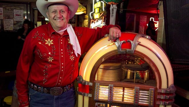 James White is the friendly and congenial owner of the South Austin honky-tonk, the Broken Spoke. In this file photo, he is standing next to a 1947 juke box near the dance floor.