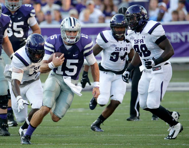 Kansas State quarterback Jake Waters (15) gets past a group of Stephen F. Austin defenders as he runs the ball during the first half of an NCAA college football game.