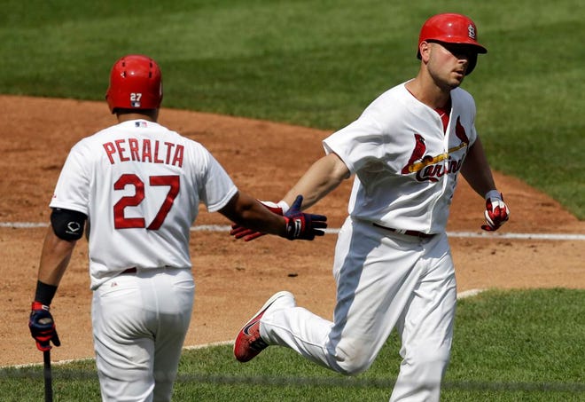 St. Louis Cardinals' Matt Holliday, right, is congratulated by teammate Jhonny Peralta after hitting a solo home run during the fourth inning of a game on Sunday in St. Louis.