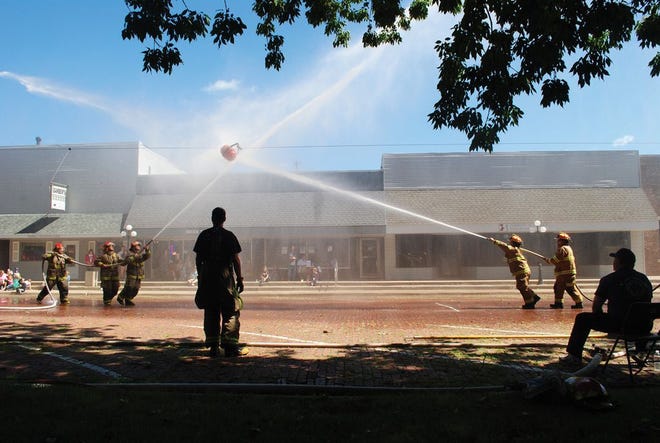Above, local firefighters compete in the hose fight competition. This year, attendees will also be able to compete in the competition. Right, chief Mike Todd speaks to the crowd in years past.