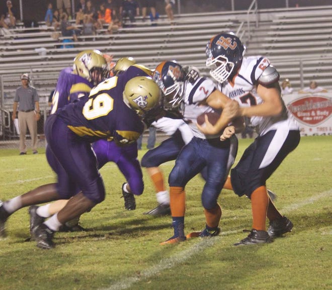 ACHS’ senior defensive end Delmond Landry tackles a Warrior during the Jamboree win Friday night.