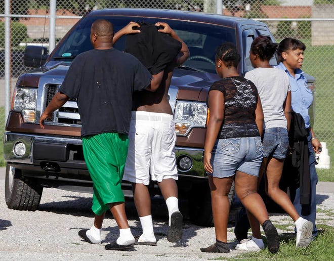 One of 32 escaped teenagers, second from left, is brought back to the Woodland Hills Youth Development Center by family members, according to a Tennessee Department of Children's Services spokesman, Tuesday, Sept. 2, 2014, in Nashville, Tenn. The teenagers, ages 14 to 19, escaped from the facility Monday night. (AP Photo/Mark Humphrey)