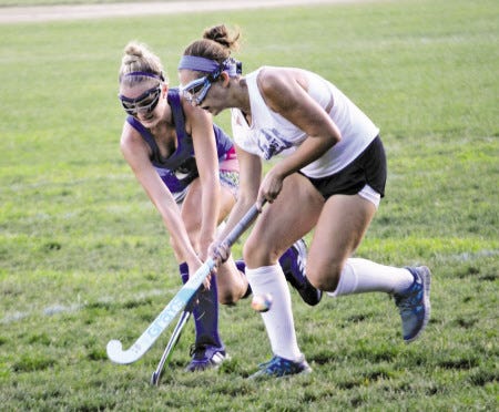 Exeter High School juniors Emma Brown (left) and Jordan Ross run through a drill during field hockey practice on Tuesday. Exeter returns as the defending Division I champion this fall.