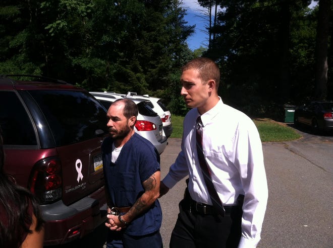 Pocono Mountain Regional Police Detective Leo Petrucci escorts Kirk Randler into district court Wednesday.