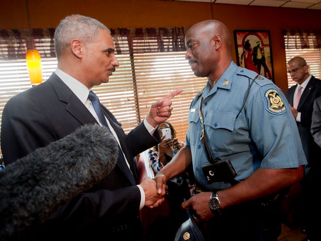 Attorney General Eric Holder talks with Capt. Ron Johnson of the Missouri State Highway Patrol at Drake's Place Restaurant on Aug. 20 in Florrissant, Mo. The Justice Department plans to open a wide-ranging investigation into the practices of the Ferguson, Missouri, Police Department following the shooting last month of an unarmed black 18-year-old by a white police officer in the St. Louis suburb, a person briefed on the matter said Wednesday.