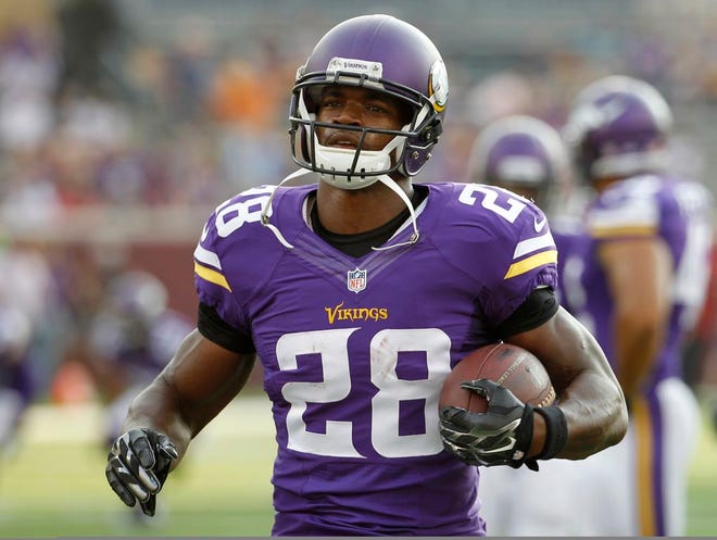 In this Aug. 16, 2014, photo, Minnesota Vikings running back Adrian Peterson (28) warms up before a NFL preseason football game against the Arizona Cardinals in Minneapolis.