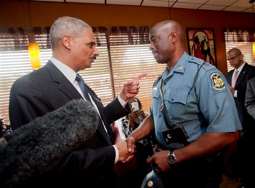 FILE - In this Aug. 20, 2014 file photo, Attorney General Eric Holder talks with Capt. Ron Johnson of the Missouri State Highway Patrol at Drake's Place Restaurant in Florrissant, Mo. The Justice Department plans to open a wide-ranging investigation into the practices of the Ferguson, Missouri, Police Department following the shooting last month of an unarmed black 18-year-old by a white police officer in the St. Louis suburb, a person briefed on the matter said Wednesday, Sept. 3, 2014.