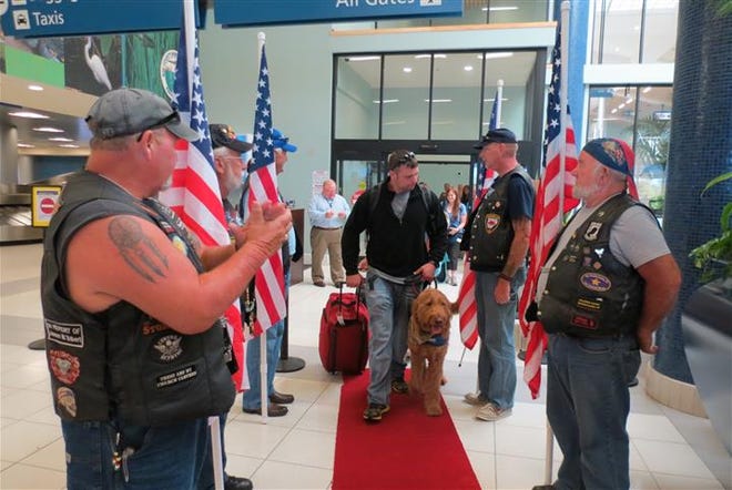Participants of the Warrior Beach Retreat are met at the airport by veterans and slews of welcoming supporters.