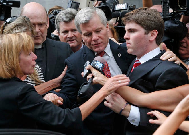 Former Virginia Gov. Bob McDonnell, center, is mobbed by media as he gets into a car with his son, Bobby, right, after he and his wife, former first lady Maureen McDonnell, were convicted on multiple counts of corruption at Federal Court in Richmond, Va., Thursday, Sept. 4, 2014. A federal jury in Richmond convicted Bob McDonnell of 11 of the 13 counts he faced; Maureen McDonnell was convicted of nine of the 13 counts she had faced. Sentencing was scheduled for Jan. 6. (AP Photo/Steve Helber)