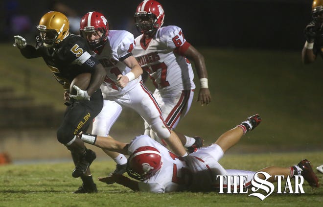 Shelby's Chad Reid dodges being tackled by South Point's Evan Preslopsky(41) and Yale Loucks(51) during Friday night's game at Shelby High School. (Ben Earp/The Star)