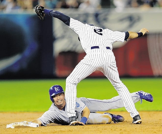 Royals' Norichika Aoki, bottom, reaches for second base while Yankees' Derek Jeter tags him out during a stolen base-attempt in the third inning.