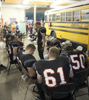 On the other side of the Jonesville Community Schools bus garage members of the Jonesville High School football team wait out the rain. ANDY BARRAND PHOTO