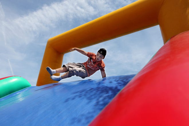 Yahir Martinez, 6, of Providence, completes an obstacle course of inflatables on Broad Street on Sunday.