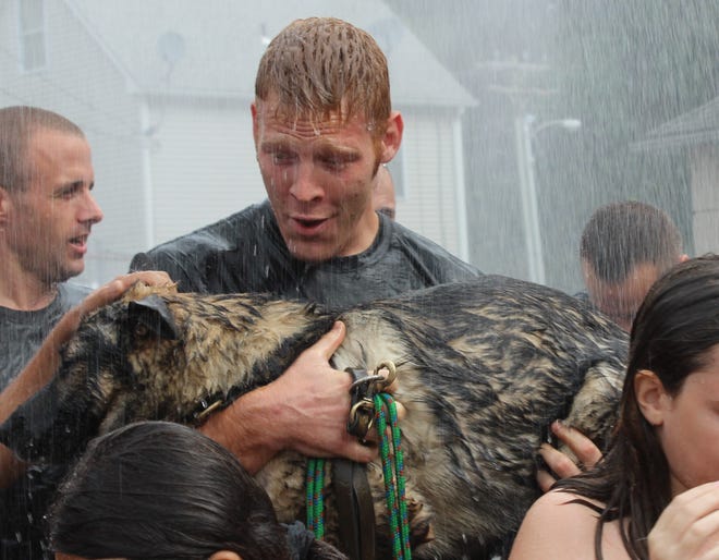 Norwich Police Officer Nick Rakin holds police dog Keeto as water drenches them from a Norwich Fire Department fire engine on Saturday during the Public Safety for Autism challenge at the station.

Nicole Wagner/ For The Bulletin